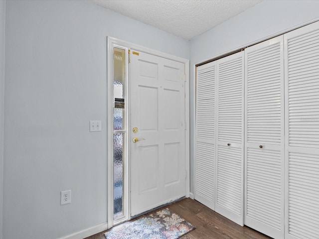 entryway featuring a textured ceiling and dark hardwood / wood-style floors