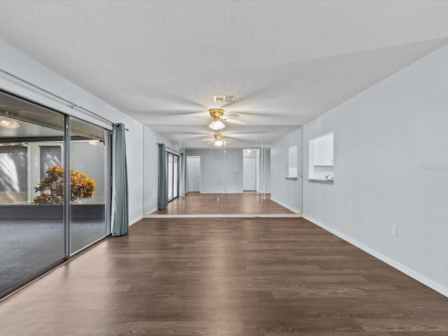 unfurnished room with a textured ceiling, ceiling fan, and dark hardwood / wood-style flooring