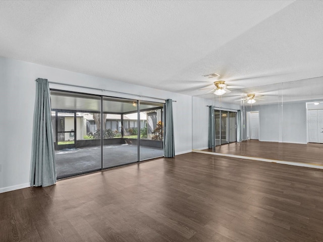 empty room featuring ceiling fan, dark hardwood / wood-style flooring, and a textured ceiling