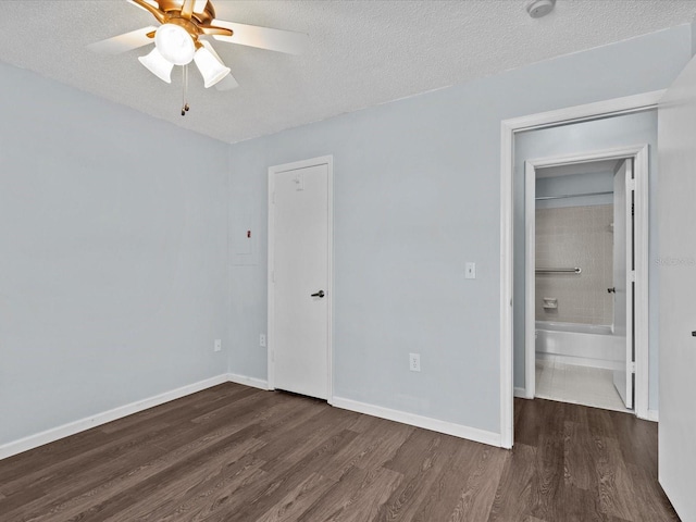 empty room featuring dark hardwood / wood-style flooring, ceiling fan, and a textured ceiling