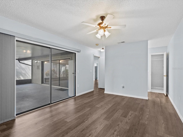 empty room with ceiling fan, dark hardwood / wood-style flooring, and a textured ceiling