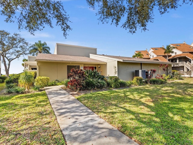 view of front of house with a front lawn and cooling unit