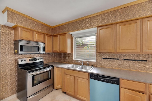 kitchen with light brown cabinets, sink, light tile patterned floors, and stainless steel appliances