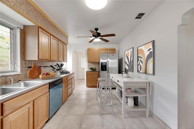 kitchen with light brown cabinetry, backsplash, ceiling fan, and appliances with stainless steel finishes