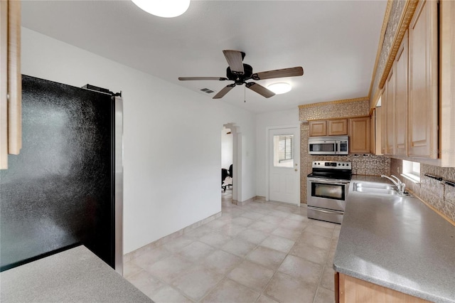 kitchen with backsplash, ceiling fan, appliances with stainless steel finishes, and sink