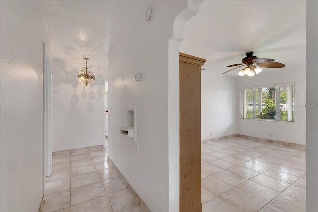 hall with a chandelier and light tile patterned floors