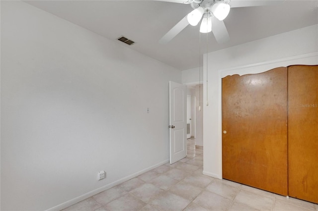 unfurnished bedroom with ceiling fan and a closet