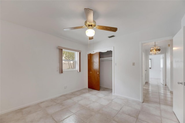 unfurnished bedroom featuring ceiling fan with notable chandelier and a closet