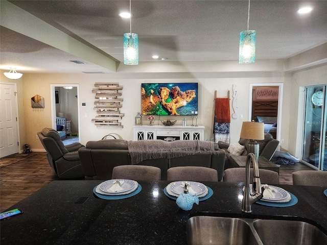 living room featuring a textured ceiling, sink, and wood-type flooring