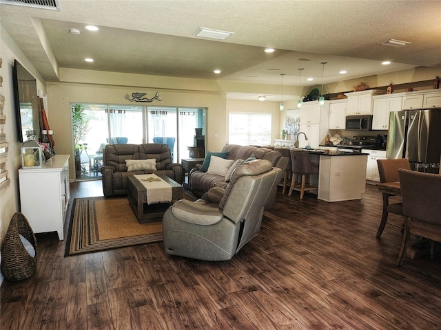 living room featuring a textured ceiling and dark hardwood / wood-style floors