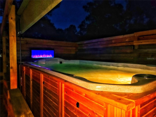 patio at twilight featuring a jacuzzi