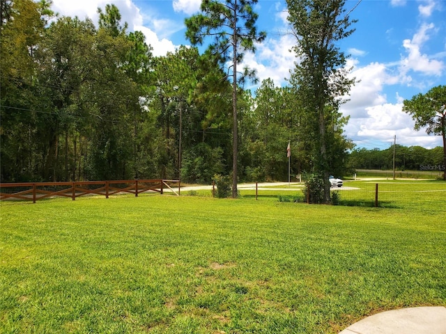 view of home's community with a lawn and fence