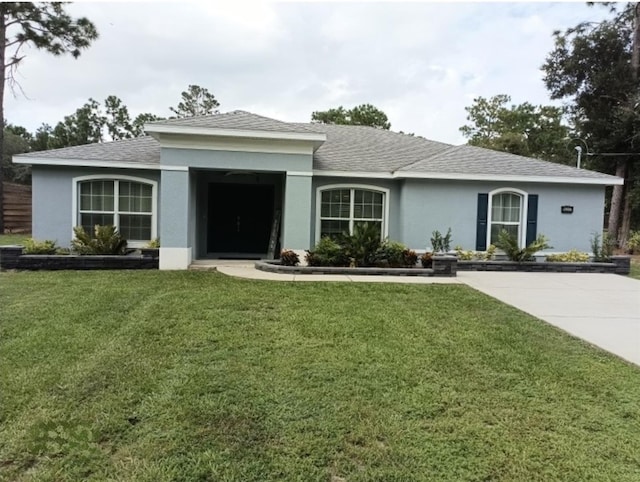 single story home featuring stucco siding, roof with shingles, and a front lawn