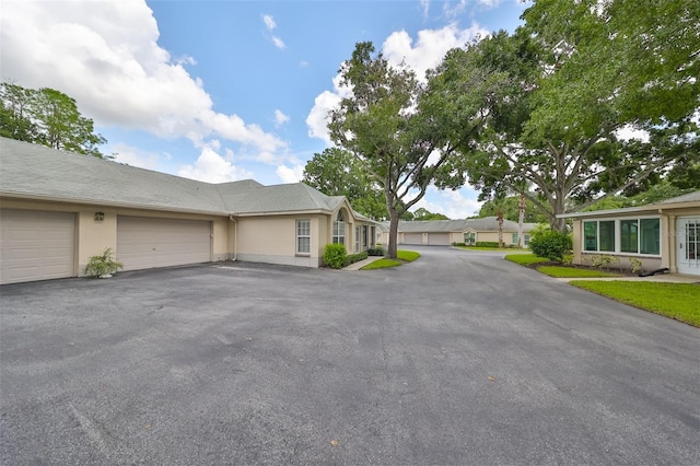 view of front of property featuring stucco siding, a garage, and driveway