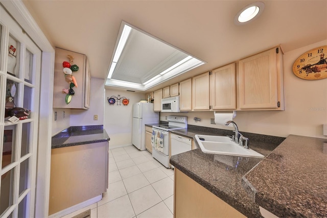 kitchen with light tile patterned floors, white appliances, light brown cabinetry, and sink