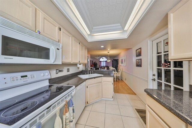 kitchen with crown molding, white appliances, light hardwood / wood-style floors, sink, and a raised ceiling