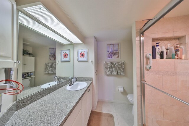 bathroom featuring vanity, toilet, tile patterned floors, and a shower with door