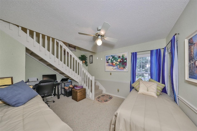 bedroom featuring ceiling fan, carpet, and a textured ceiling