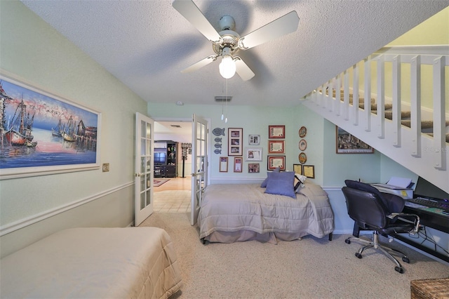 carpeted bedroom with ceiling fan, a textured ceiling, and french doors