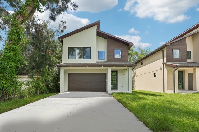 contemporary house with a front yard and a garage