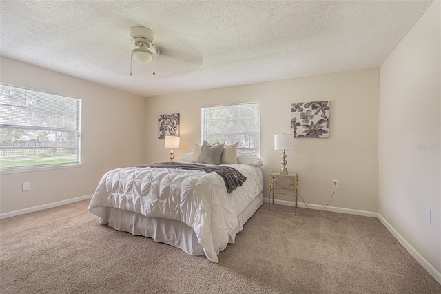 bedroom with a textured ceiling, carpet flooring, and ceiling fan