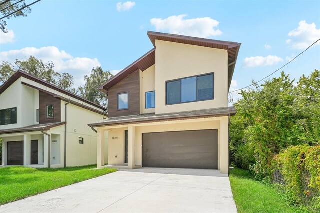 contemporary home with a garage and a front yard