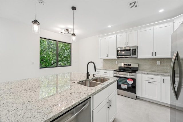 kitchen featuring white cabinets, light tile patterned floors, decorative light fixtures, stainless steel appliances, and sink