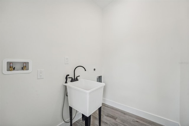 laundry room with washer hookup, hookup for an electric dryer, sink, and light hardwood / wood-style flooring