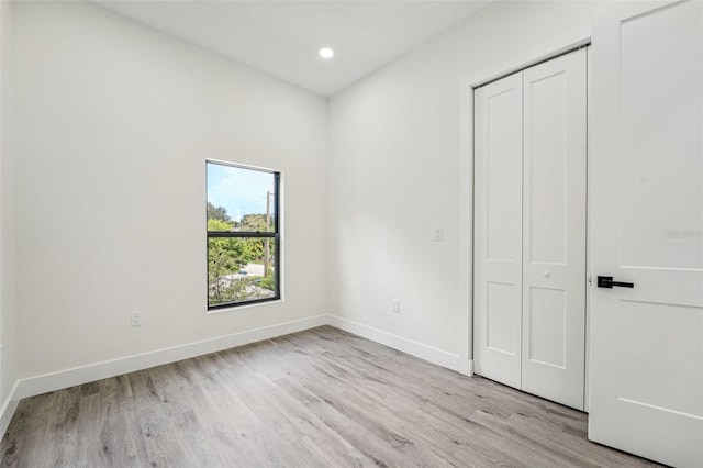 unfurnished bedroom featuring a closet and light hardwood / wood-style floors