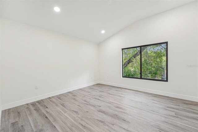 unfurnished room with lofted ceiling and light hardwood / wood-style flooring