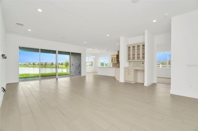 unfurnished living room featuring recessed lighting, light wood-type flooring, baseboards, and visible vents