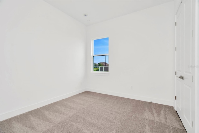 carpeted spare room featuring baseboards