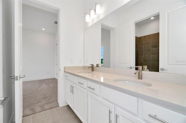 bathroom with tile patterned floors, double vanity, baseboards, and a sink