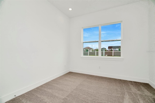 carpeted empty room featuring recessed lighting and baseboards