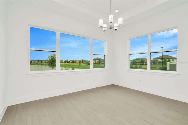 empty room with wood finished floors, baseboards, and a chandelier