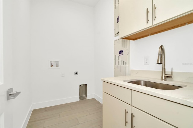 laundry area with baseboards, hookup for an electric dryer, cabinet space, a sink, and washer hookup