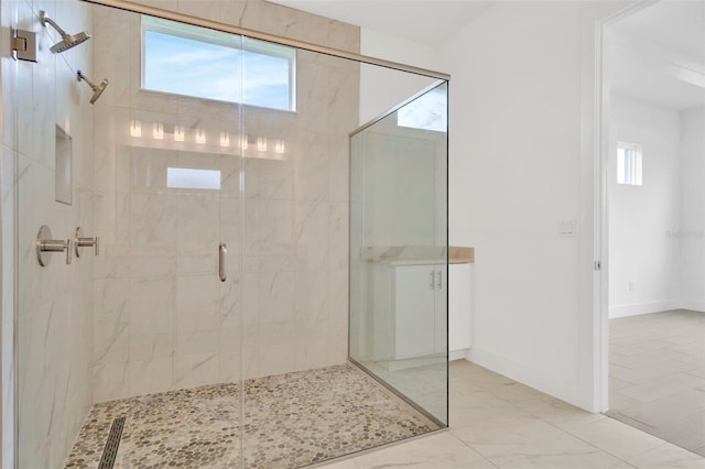 full bath featuring a shower stall, baseboards, and marble finish floor