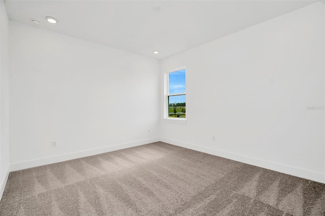 empty room with carpet flooring, recessed lighting, and baseboards