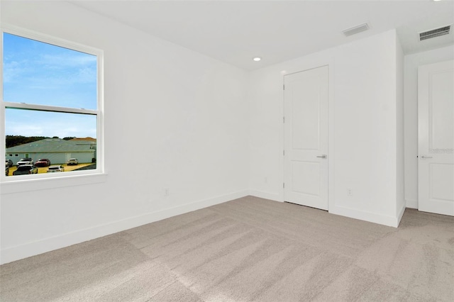 carpeted spare room with visible vents, recessed lighting, and baseboards