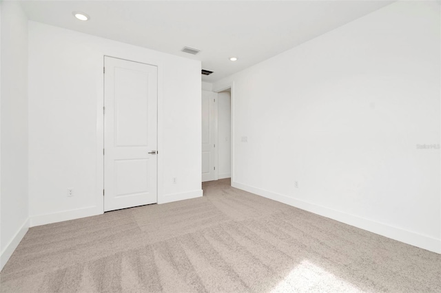 carpeted spare room with visible vents, recessed lighting, and baseboards