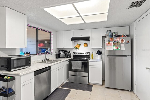 kitchen featuring white cabinetry, a textured ceiling, light tile patterned floors, sink, and appliances with stainless steel finishes