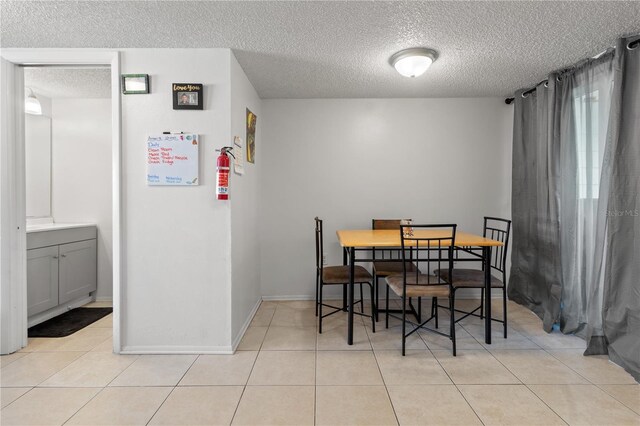 dining room with a textured ceiling and light tile patterned floors