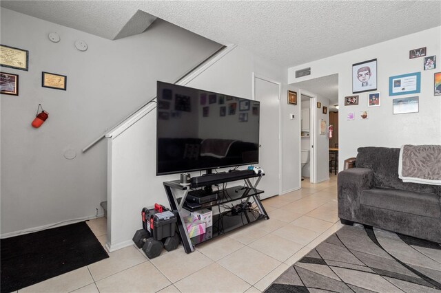 living room with a textured ceiling and light tile patterned flooring