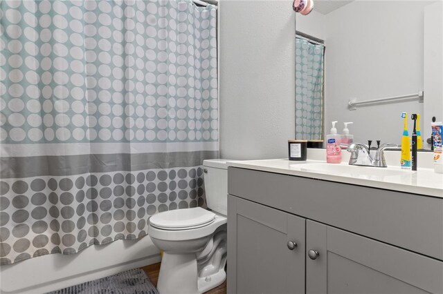 full bathroom with vanity, toilet, wood-type flooring, and shower / bath combo