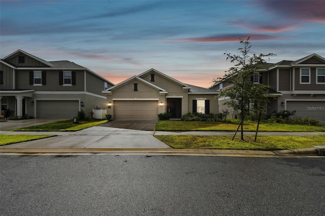 view of front of property featuring a front yard, a garage, driveway, and stucco siding