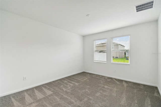 empty room with visible vents, carpet floors, and baseboards