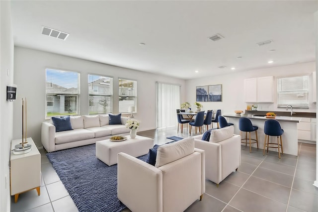 living room with light tile patterned flooring, recessed lighting, and visible vents