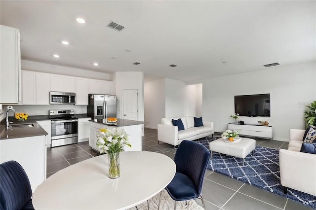 dining space with dark tile patterned floors, visible vents, and recessed lighting