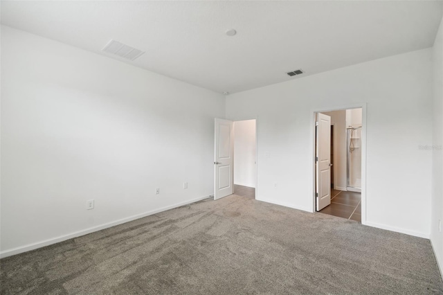 unfurnished bedroom featuring visible vents, baseboards, and carpet