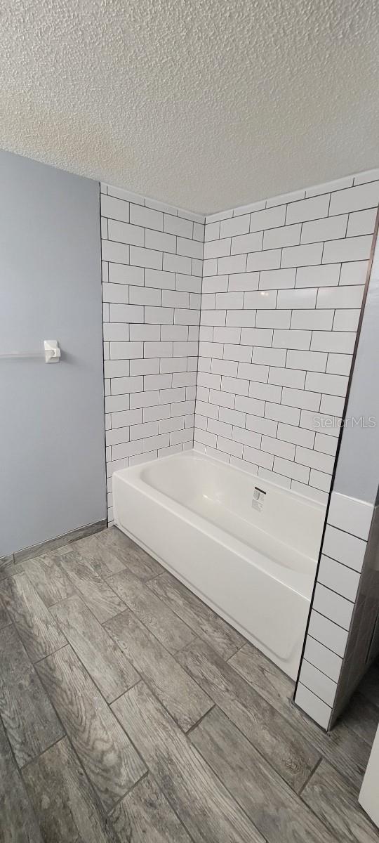 bathroom featuring a textured ceiling and hardwood / wood-style flooring